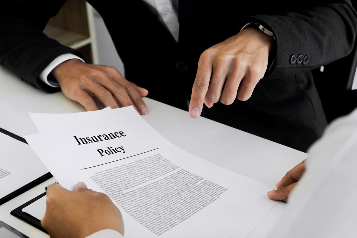 Businessmen examining and discussing insurance policy papers