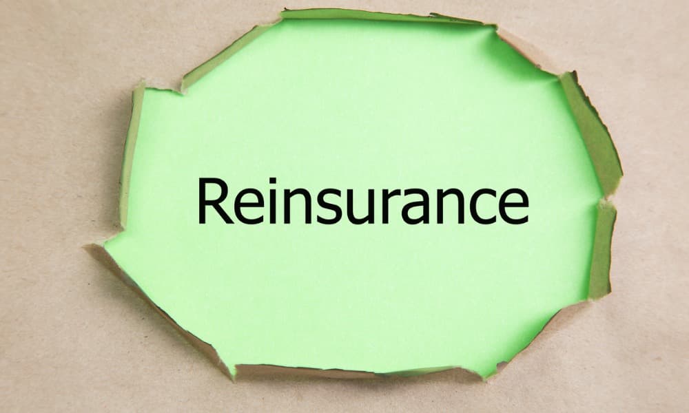 The word “reinsurance” on green paper visible beneath torn beige paper