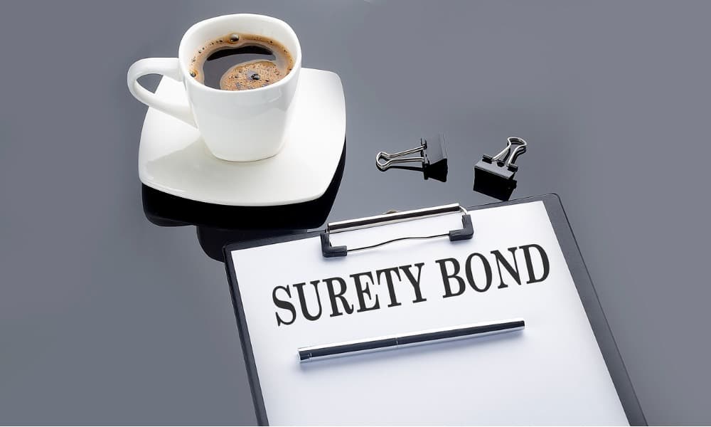 A surety bond sheet on a black table beside a cup of coffee
