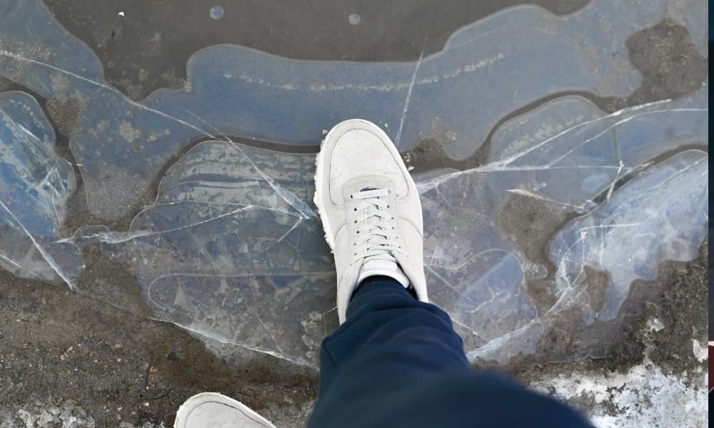 A man’s shoes on top of cracked ice