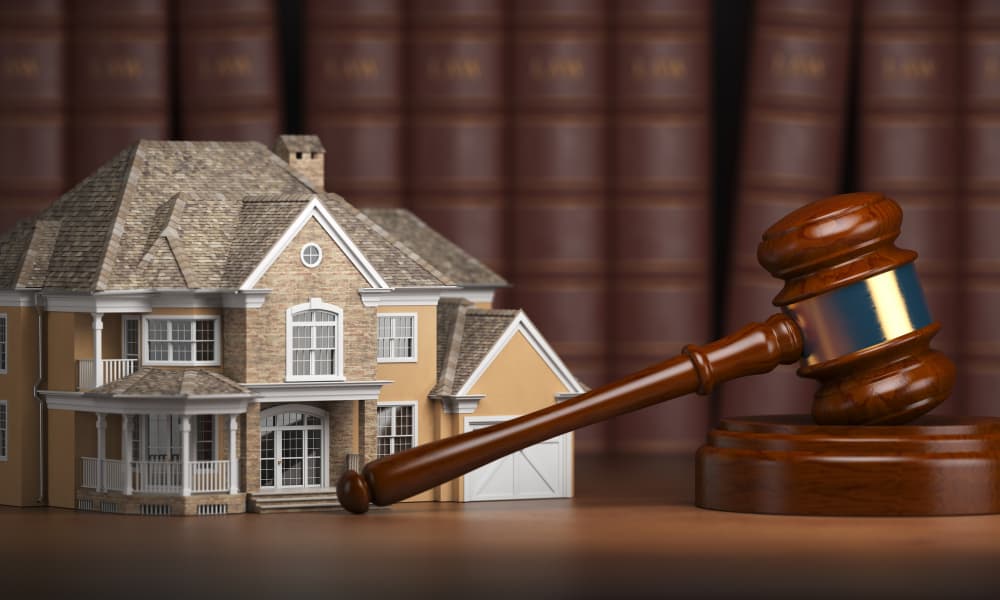 A house with gravel and law books indicating real estate law.