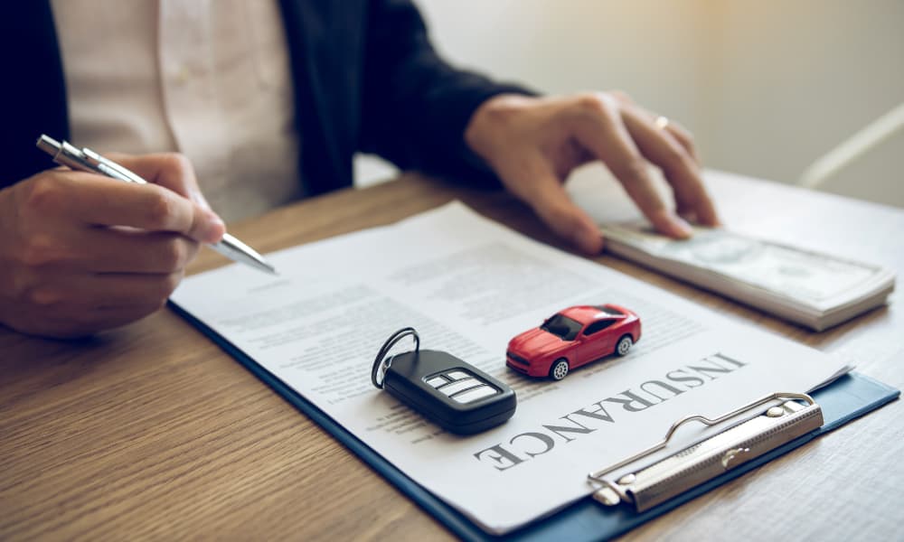 Driver signing an auto insurance contract.